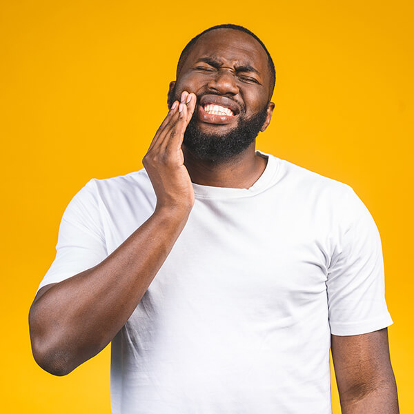 man holding his jaw in pain